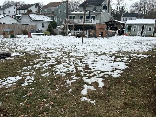 a view of a house with a yard covered in snow