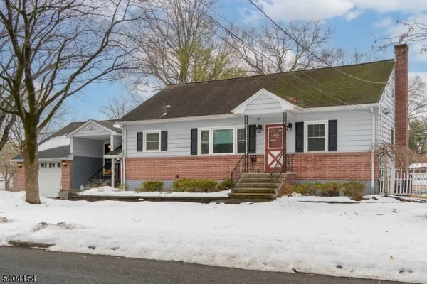 a front view of a house with a yard covered in snow