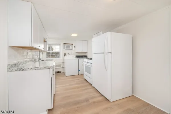 a kitchen with white cabinets and white appliances