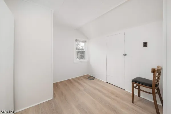 a view of a room with wooden floor and a window
