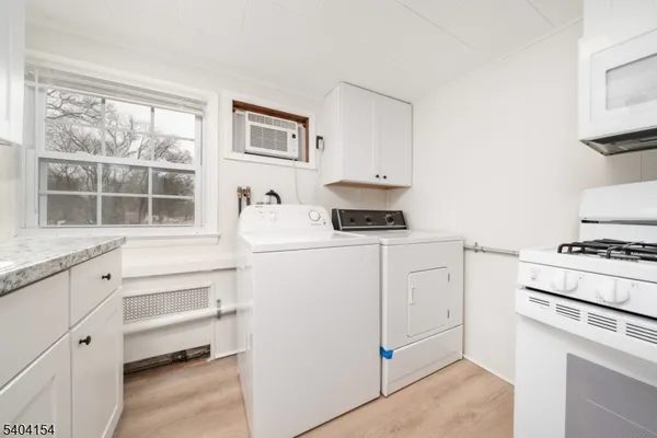 a kitchen with white cabinets and white appliances