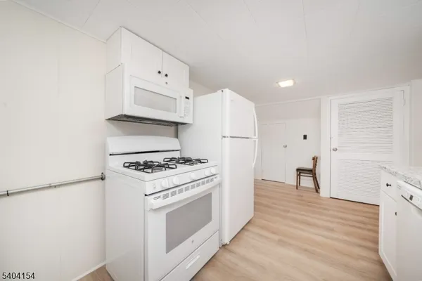 a kitchen with cabinets appliances and wooden floor