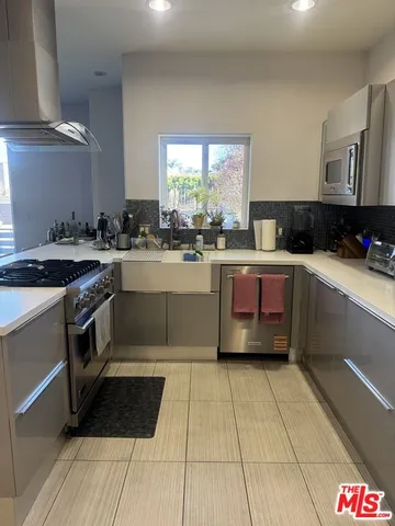 a kitchen with stainless steel appliances a stove a sink and a counter