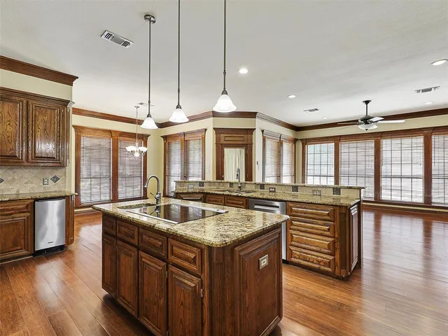 a kitchen with granite countertop a sink a counter top space and living room area