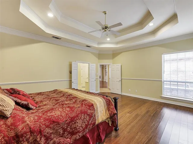 a bedroom with a large bed and a ceiling fan