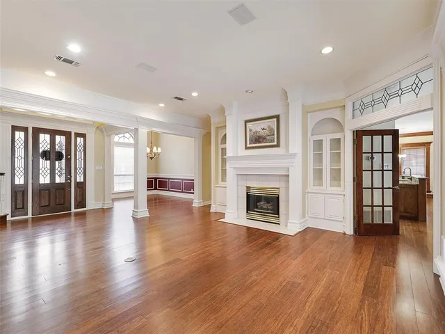 a view of a big room with wooden floor and a fireplace