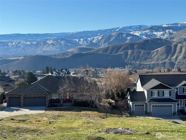 an aerial view of a house with a garden and mountains