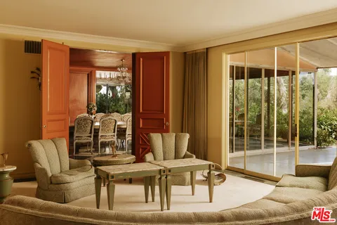 a living room with furniture a fireplace and a large window