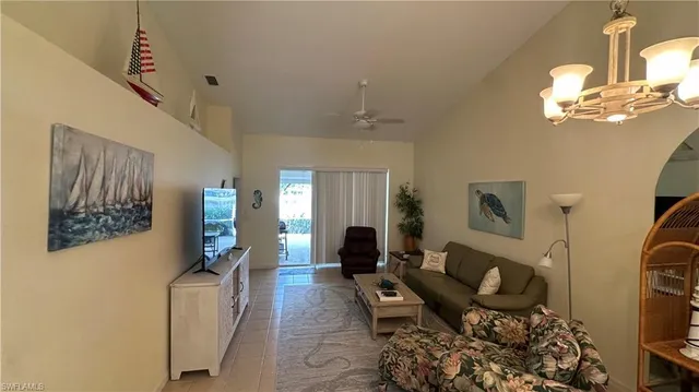 a living room with furniture flowerpot and a chandelier