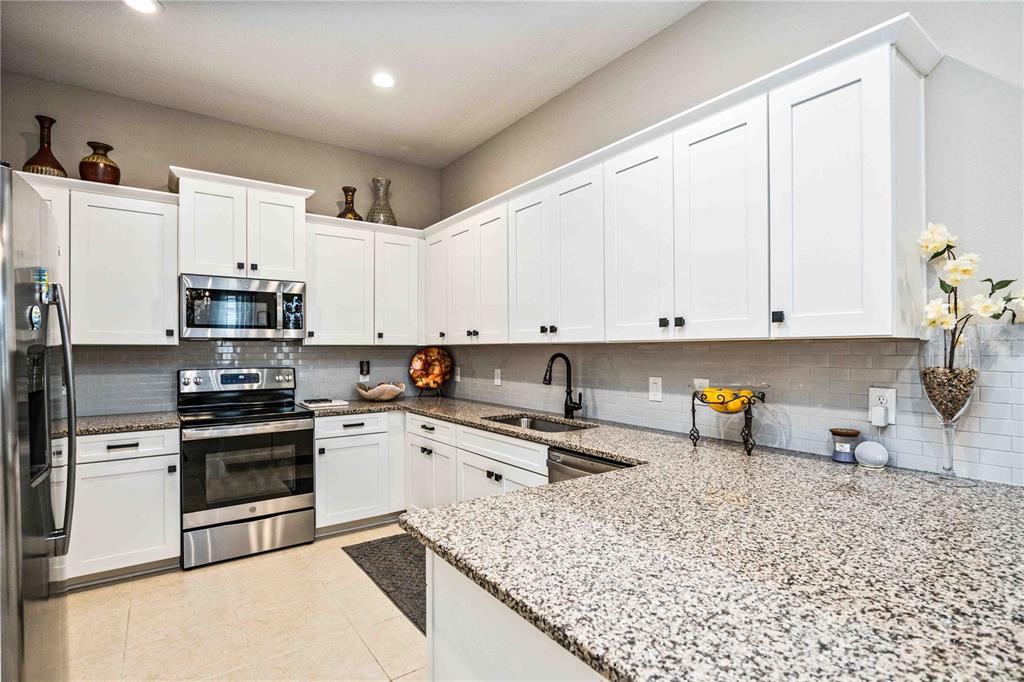 1759 Nottingham Trail Punta Gorda, FL 33980 - Photo 7 of 27 a kitchen with stainless steel appliances granite countertop a sink stove and refrigerator