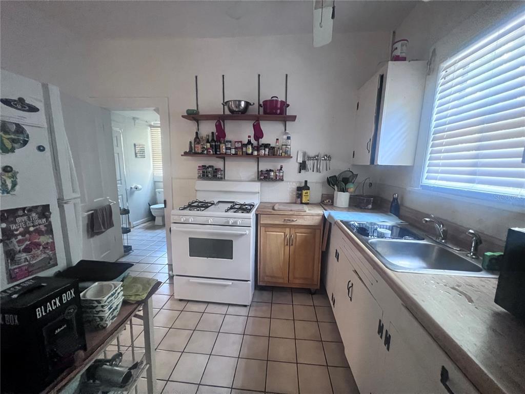 2707 Northwest 4th Avenue Gainesville, FL 32607 - Photo 25 of 31 a kitchen with a sink stove top oven and cabinets