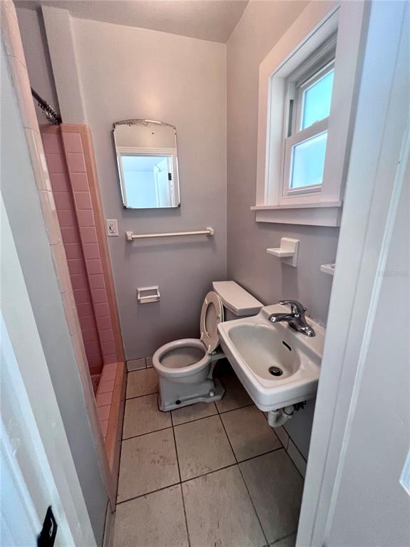 2707 Northwest 4th Avenue Gainesville, FL 32607 - Photo 7 of 31 a bathroom with a toilet a sink a mirror and a window