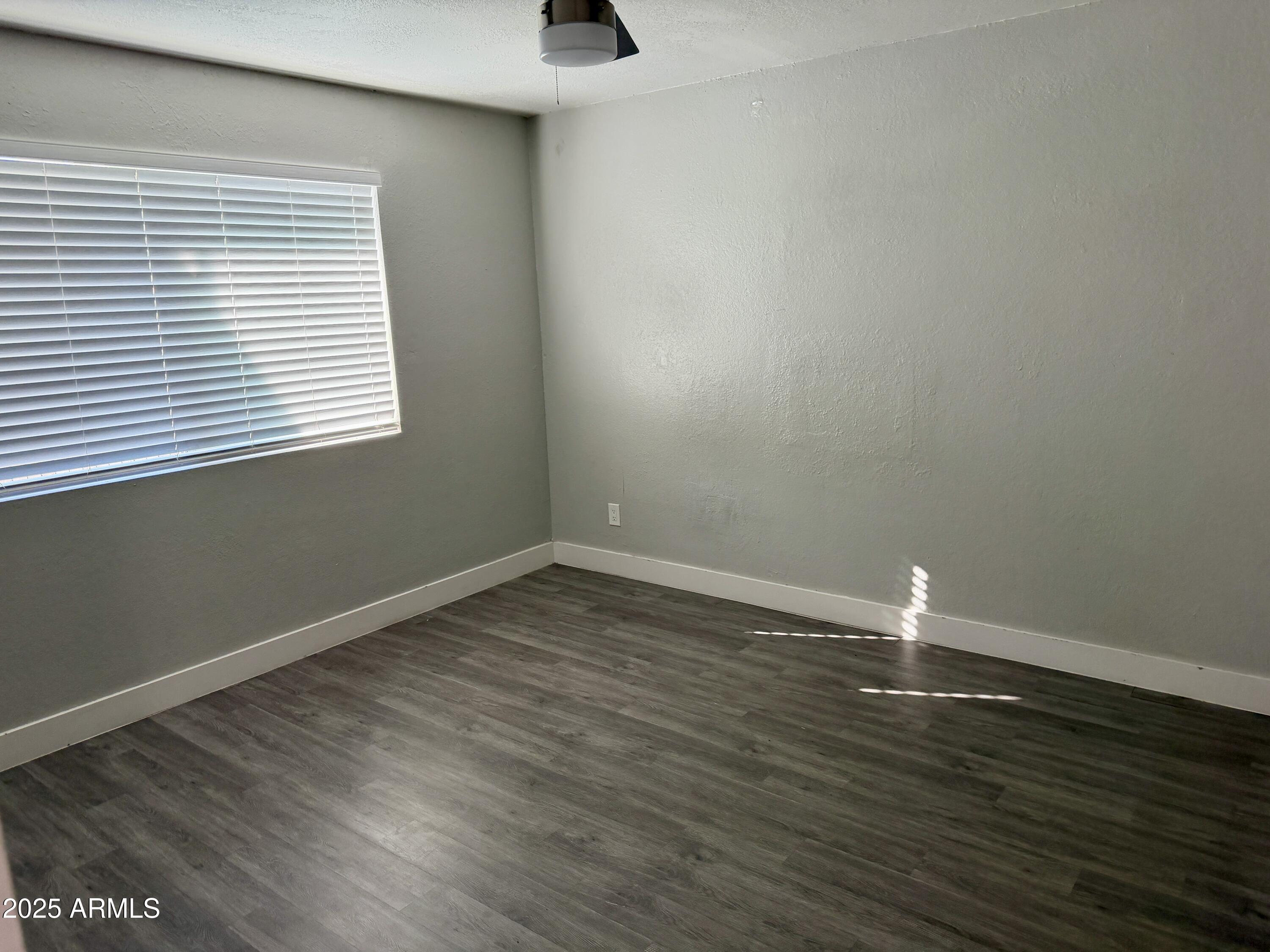 5027 North 16th Avenue, Unit 1 Phoenix, AZ 85015 - Photo 7 of 9 a view of wooden floor and windows in a room