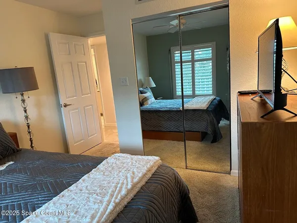 a bedroom with a bed and a dresser next to a window