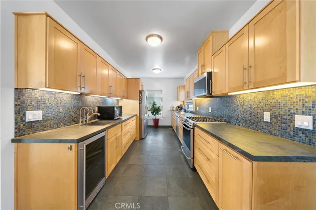 a large kitchen with stainless steel appliances granite countertop a lot of counter space and a sink