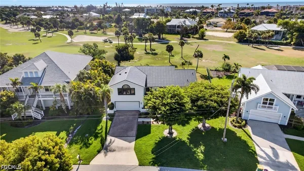 an aerial view of a house with a garden and lake view