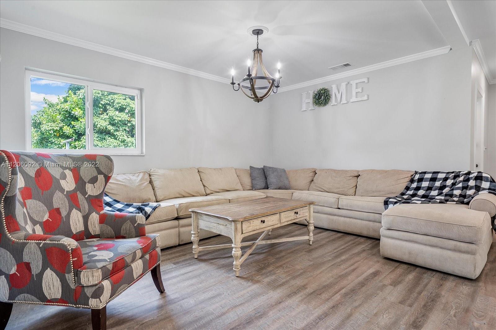 17300 Southwest 294th Street Homestead, FL 33030 - Photo 13 of 50 a living room with furniture chandelier and window