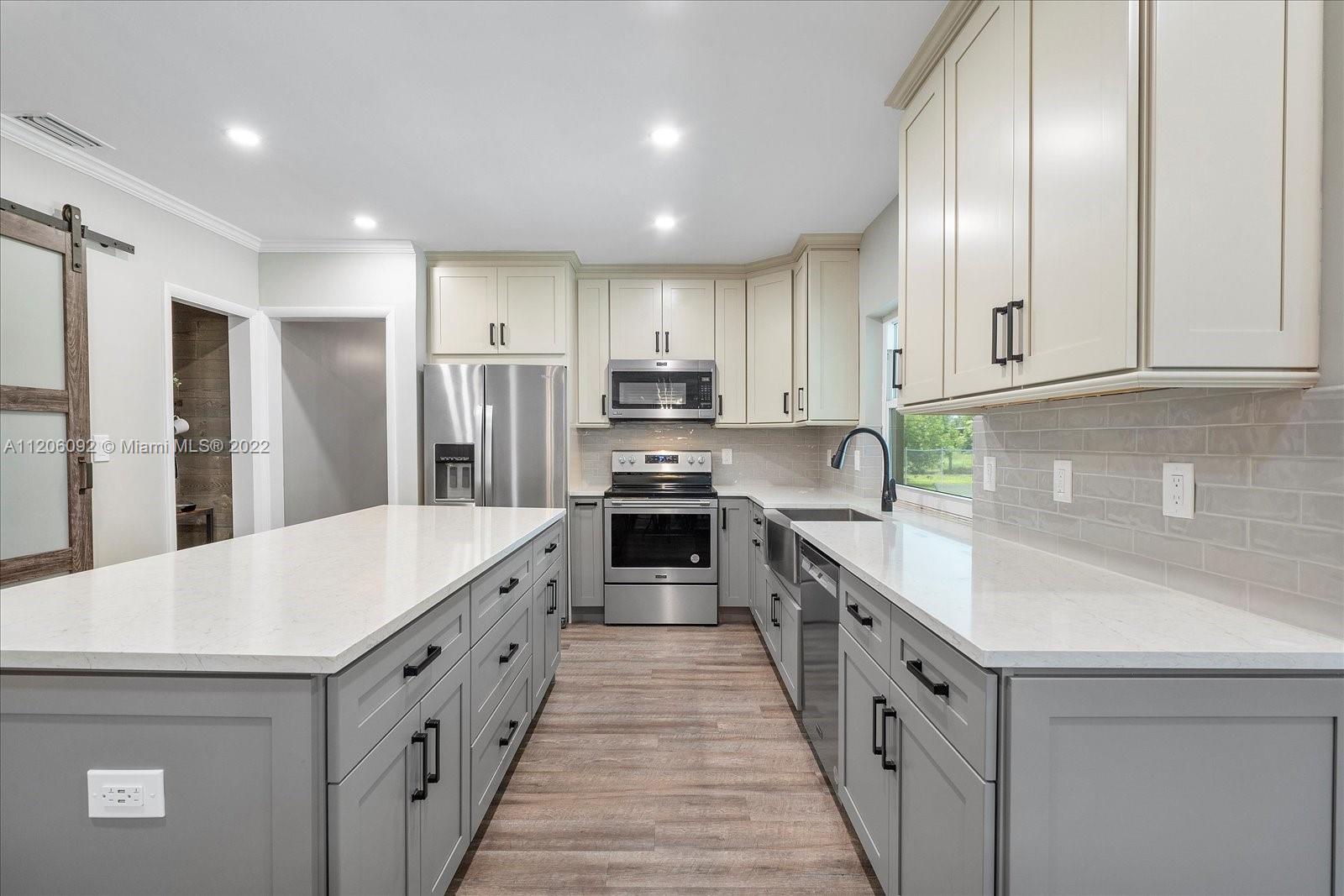 17300 Southwest 294th Street Homestead, FL 33030 - Photo 18 of 50 a large kitchen with stainless steel appliances granite countertop a stove a sink and a refrigerator