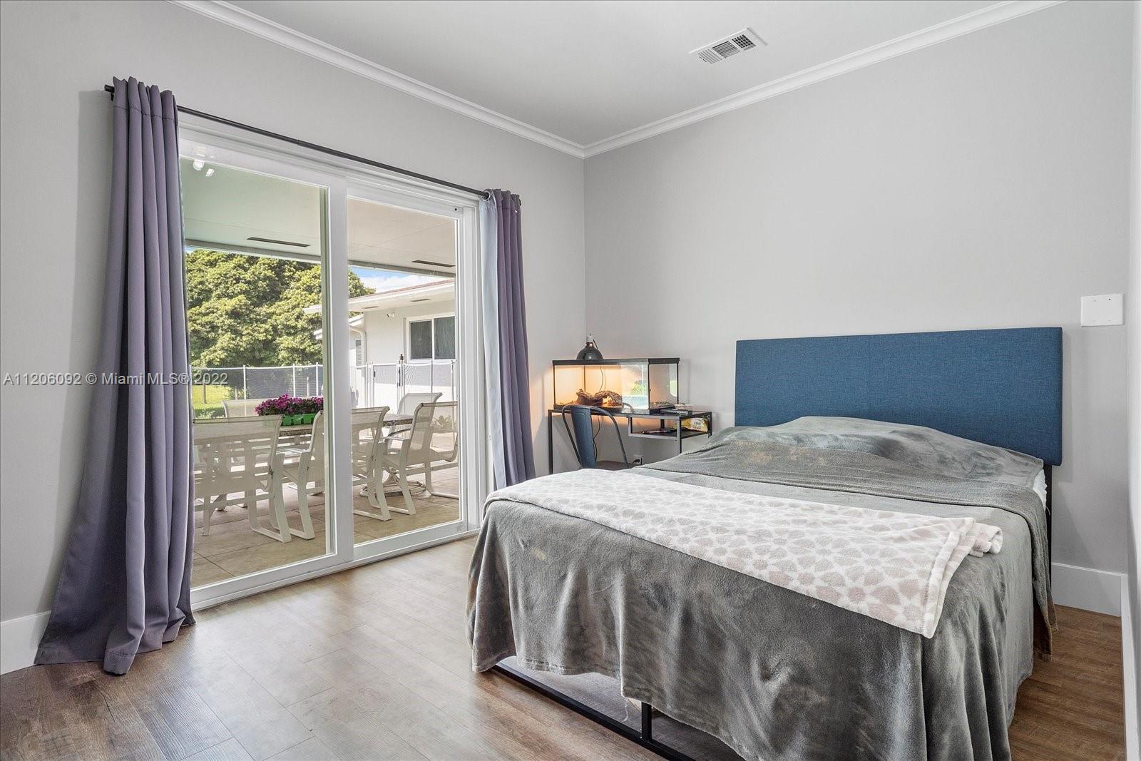 17300 Southwest 294th Street Homestead, FL 33030 - Photo 23 of 50 a bedroom with a large bed and wooden floor