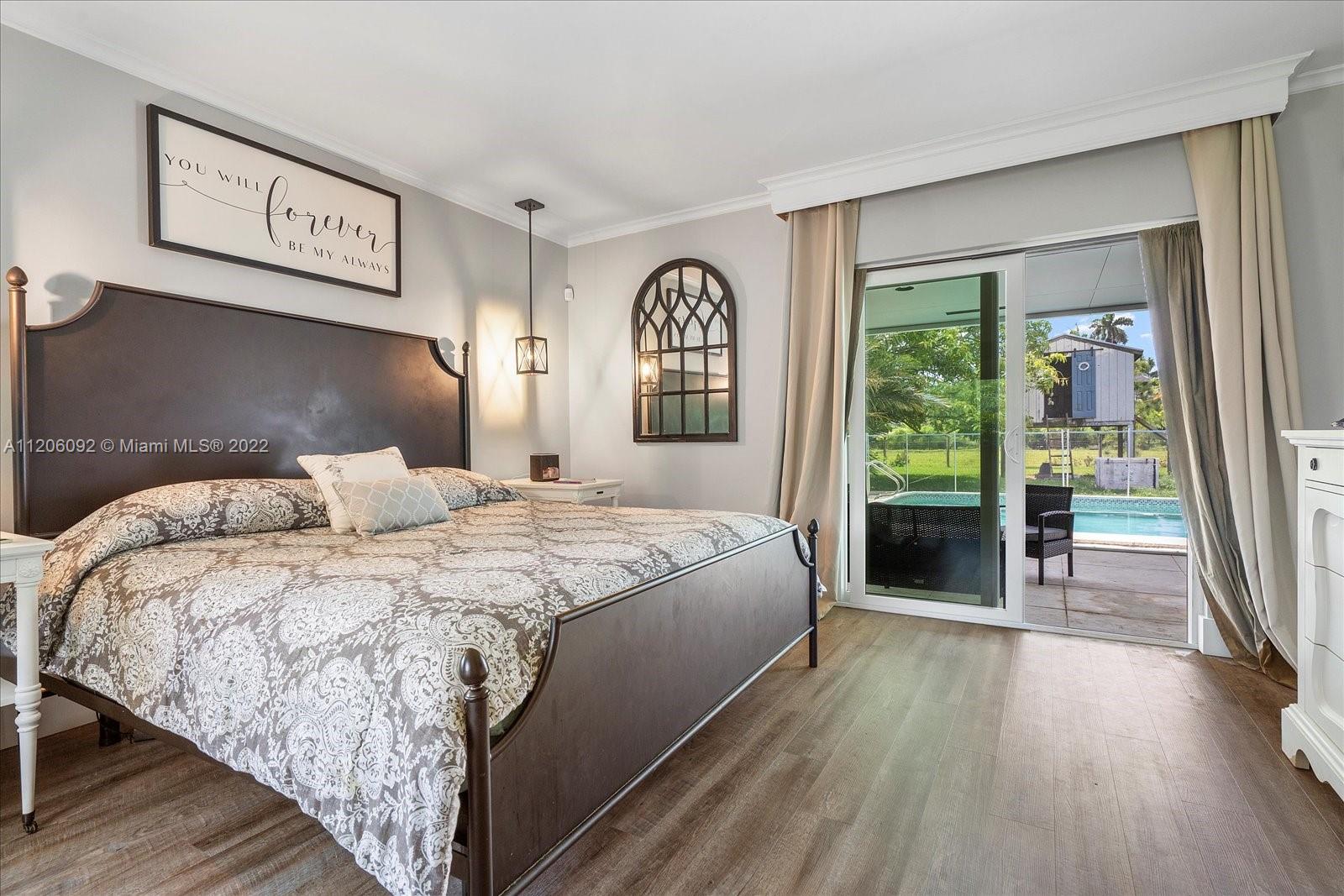 17300 Southwest 294th Street Homestead, FL 33030 - Photo 33 of 50 a spacious bedroom with a bed and a large window