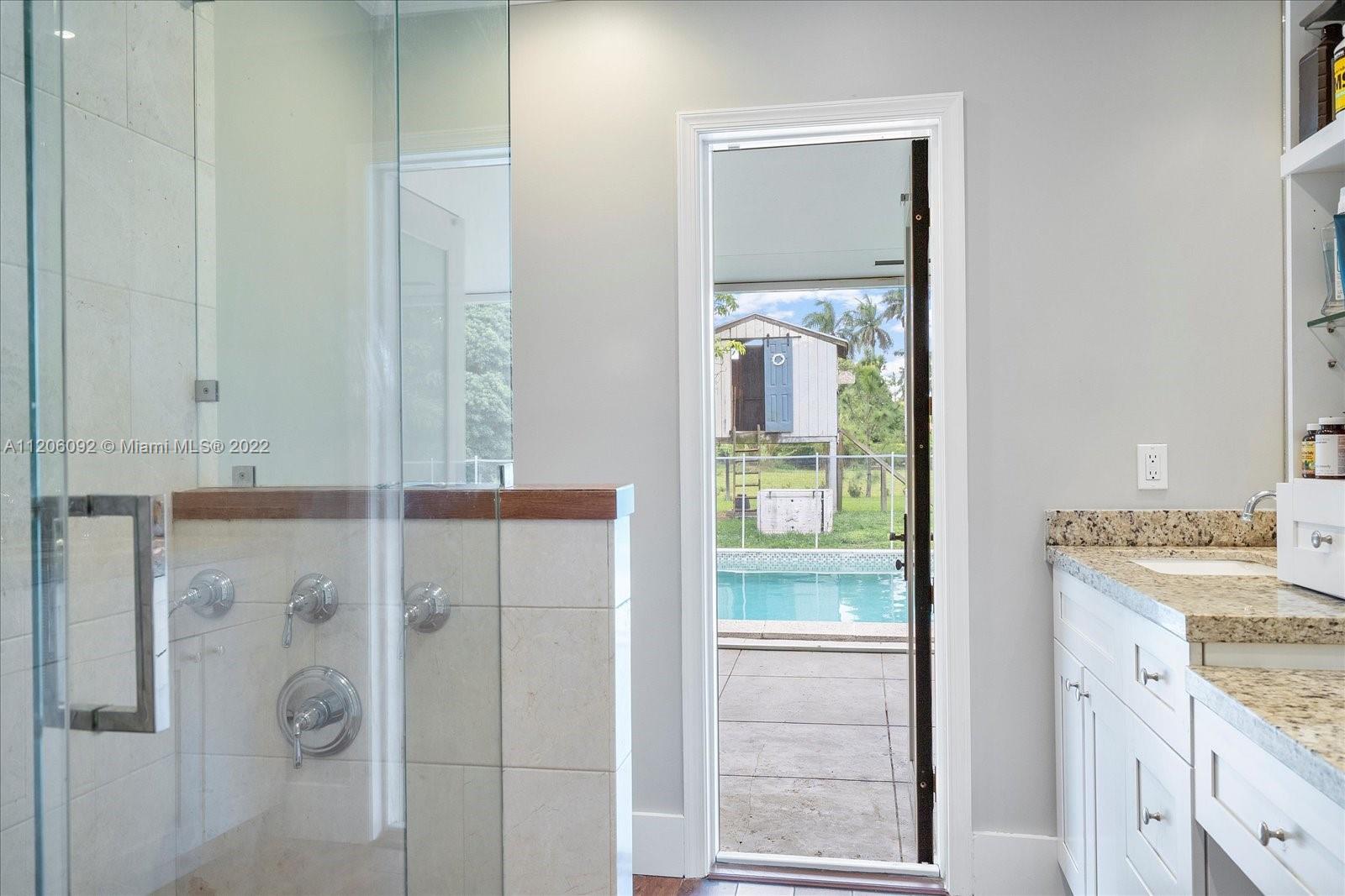 17300 Southwest 294th Street Homestead, FL 33030 - Photo 35 of 50 a bathroom with a granite countertop sink a mirror and shower