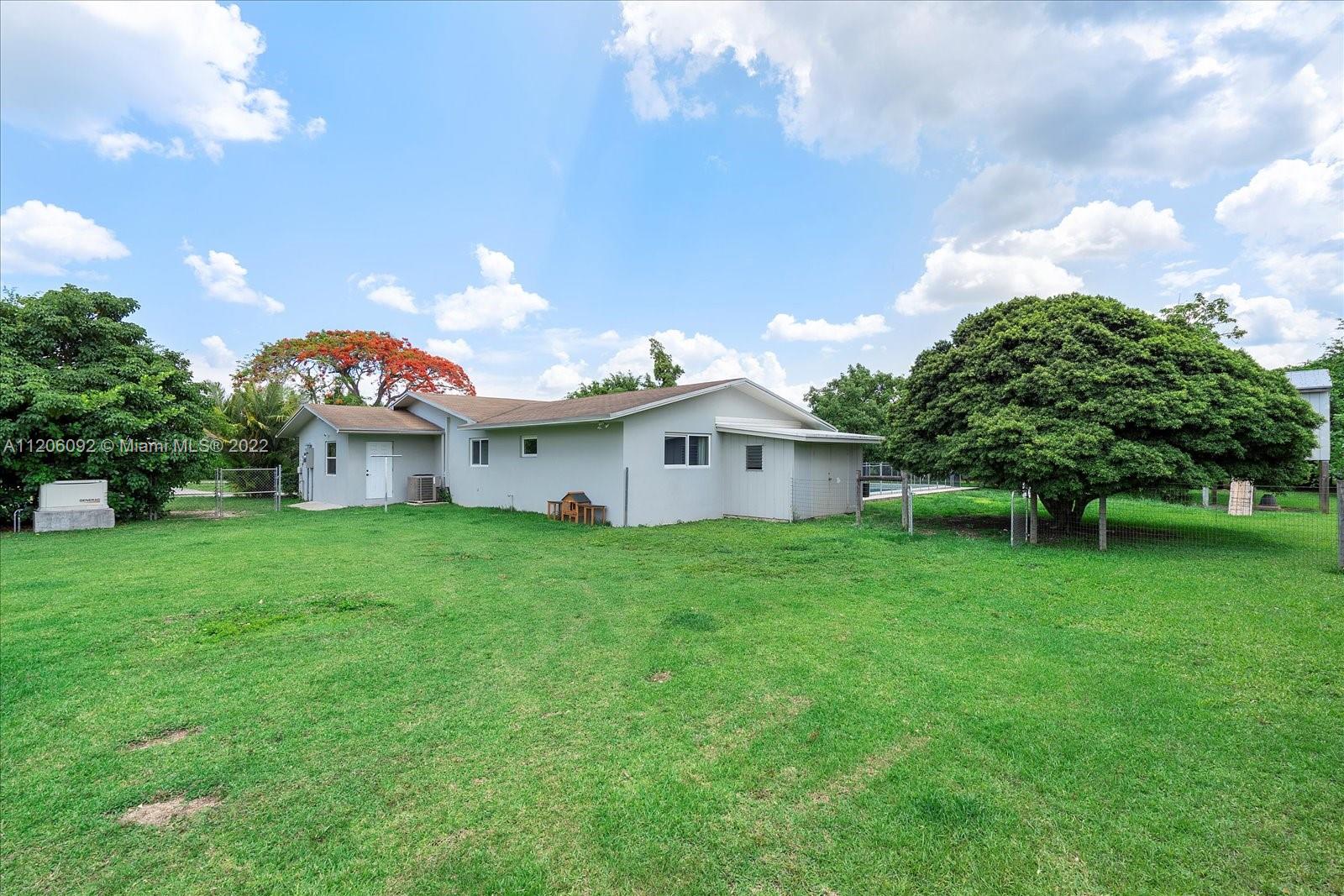 17300 Southwest 294th Street Homestead, FL 33030 - Photo 38 of 50 a view of a house with a big yard potted plants and a large tree