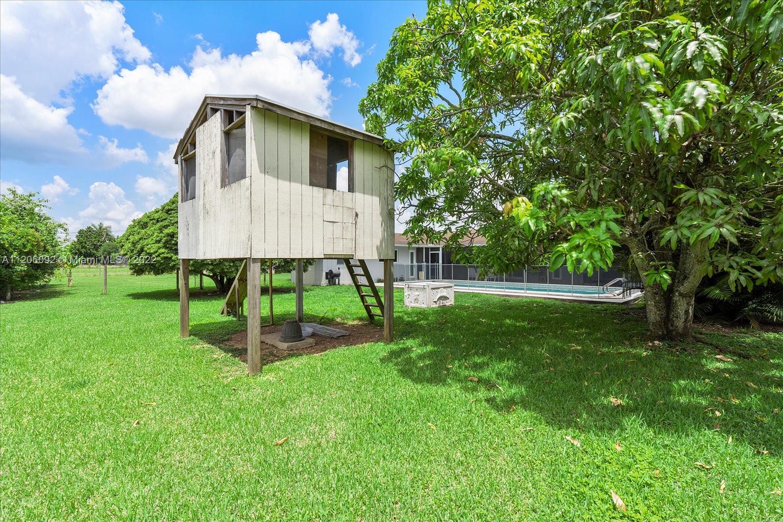 17300 Southwest 294th Street Homestead, FL 33030 - Photo 42 of 50 a view of a house with a yard fire pit and a large tree