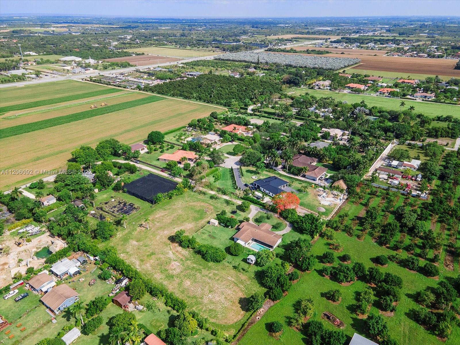 17300 Southwest 294th Street Homestead, FL 33030 - Photo 47 of 50 an aerial view of a city with lots of residential buildings and mountain view in back