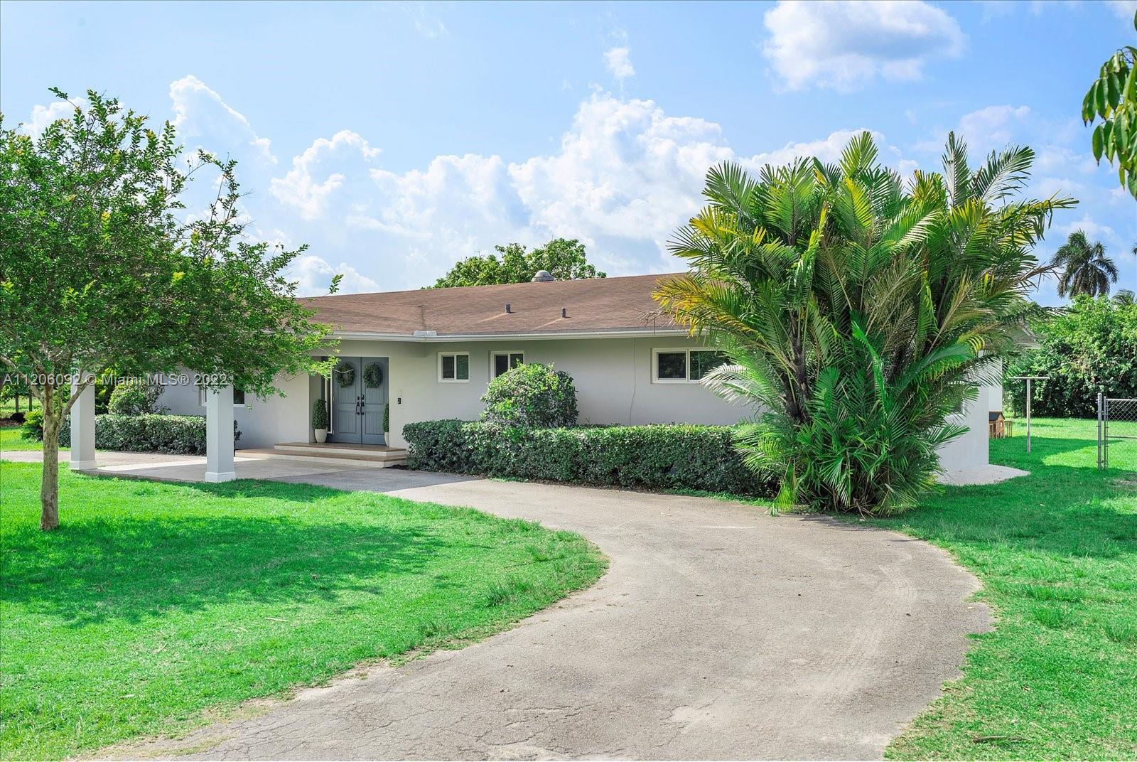 17300 Southwest 294th Street Homestead, FL 33030 - Photo 5 of 50 a front view of a house with a yard and trees