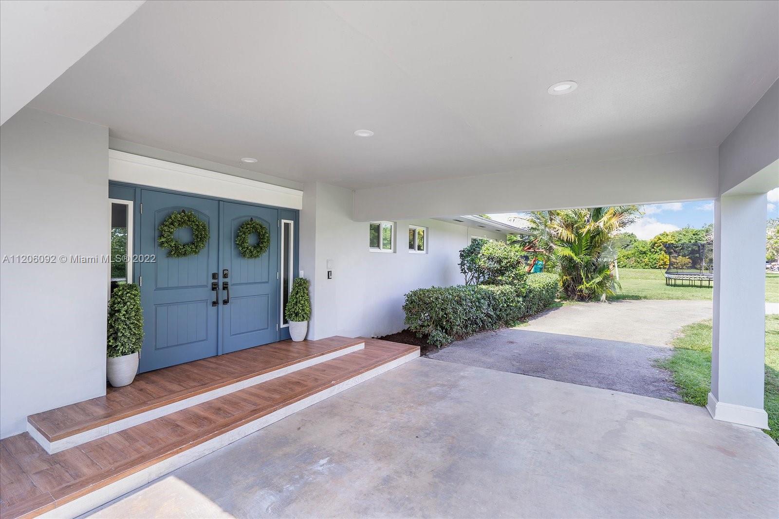 17300 Southwest 294th Street Homestead, FL 33030 - Photo 7 of 50 a view of a hallway with potted plants in front of door