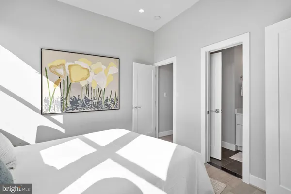 a bedroom with a bed and a painting on the wall