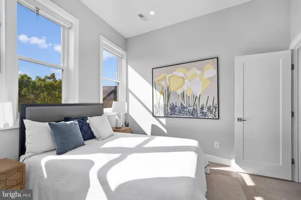 a bedroom with a bed and a painting on the wall
