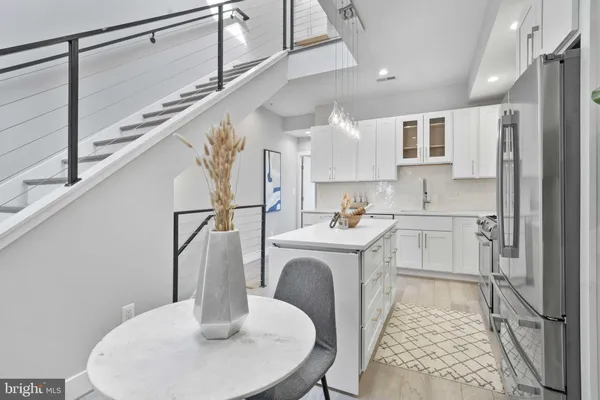 a kitchen with stainless steel appliances granite countertop a sink and a refrigerator