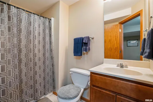 a bathroom with a sink a toilet and shower curtain