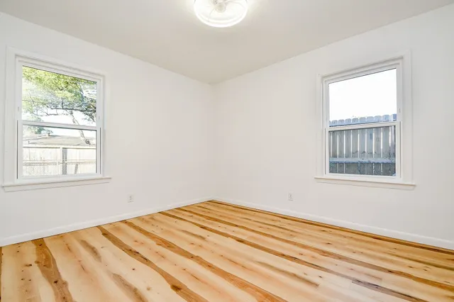 a view of a room with wooden floor and window