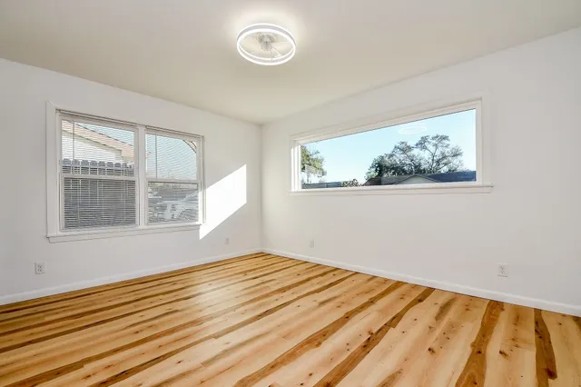 a view of empty room with wooden floor