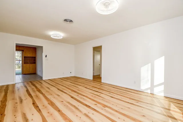 a view of a bedroom with wooden floor and bathroom
