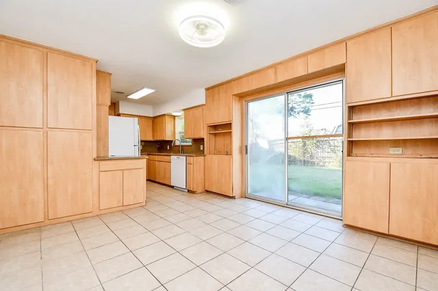 a kitchen with a refrigerator a stove top oven and cabinets