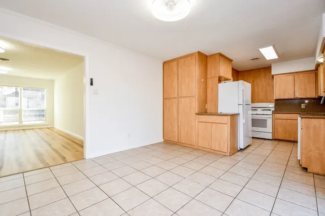 a kitchen with granite countertop a refrigerator and a stove top oven