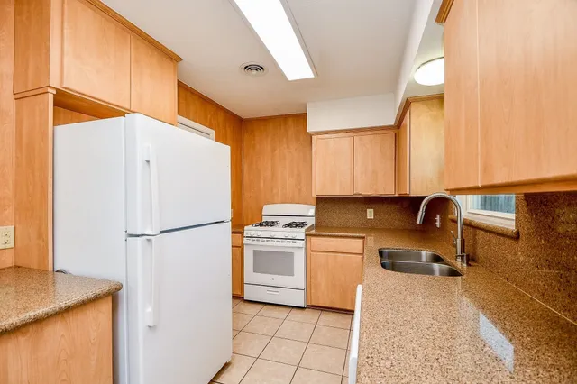 a kitchen with a refrigerator a stove a sink and a counter top space