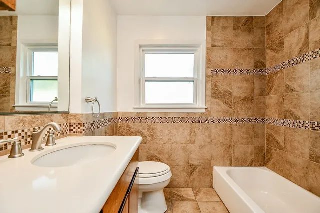 a bathroom with a sink a toilet and shower