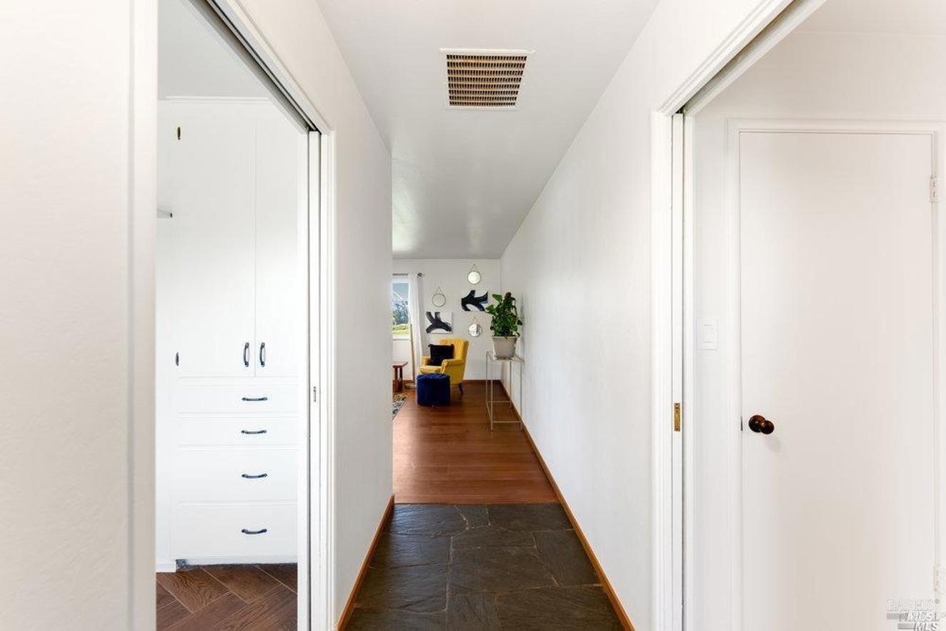 a view of a hallway with wooden floor and staircase