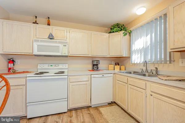 a kitchen with cabinets appliances a sink and a window
