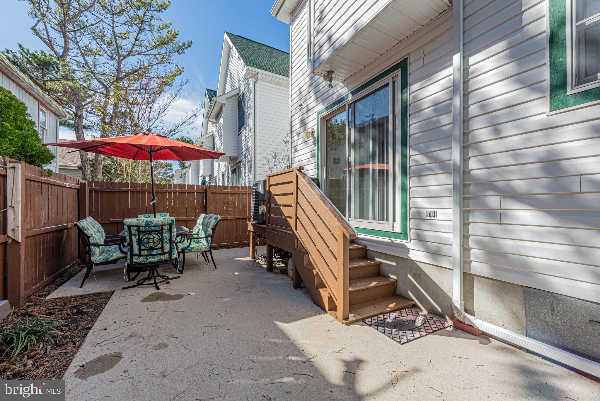 135 Captains Quarters Road Ocean City, MD 21842 - Photo 3 of 27 a view of backyard with a table and chairs under an umbrella