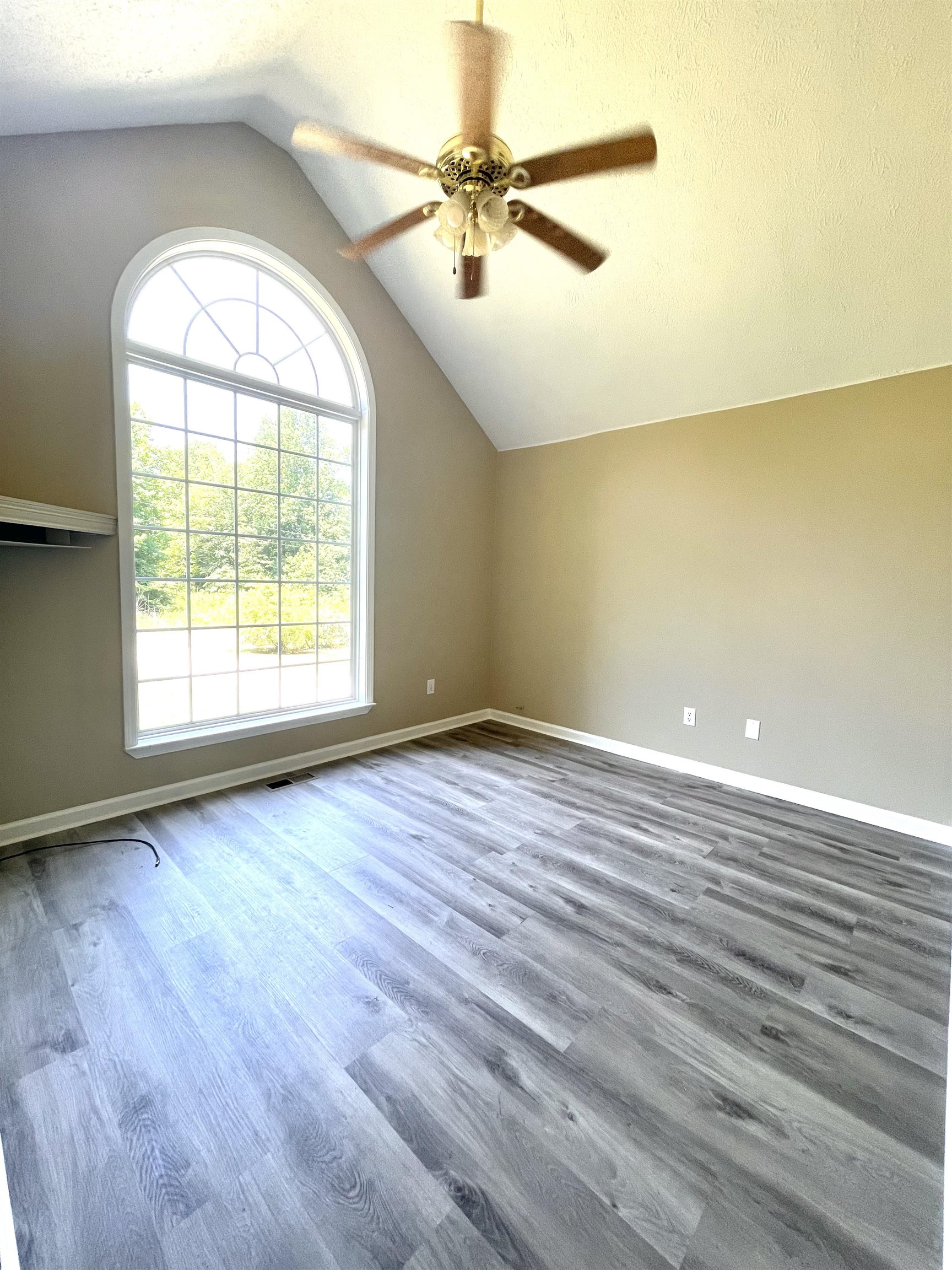 131 Wayne Elam Road Ramer, TN 38367 - Photo 11 of 15 an empty room with wooden floor fan and windows
