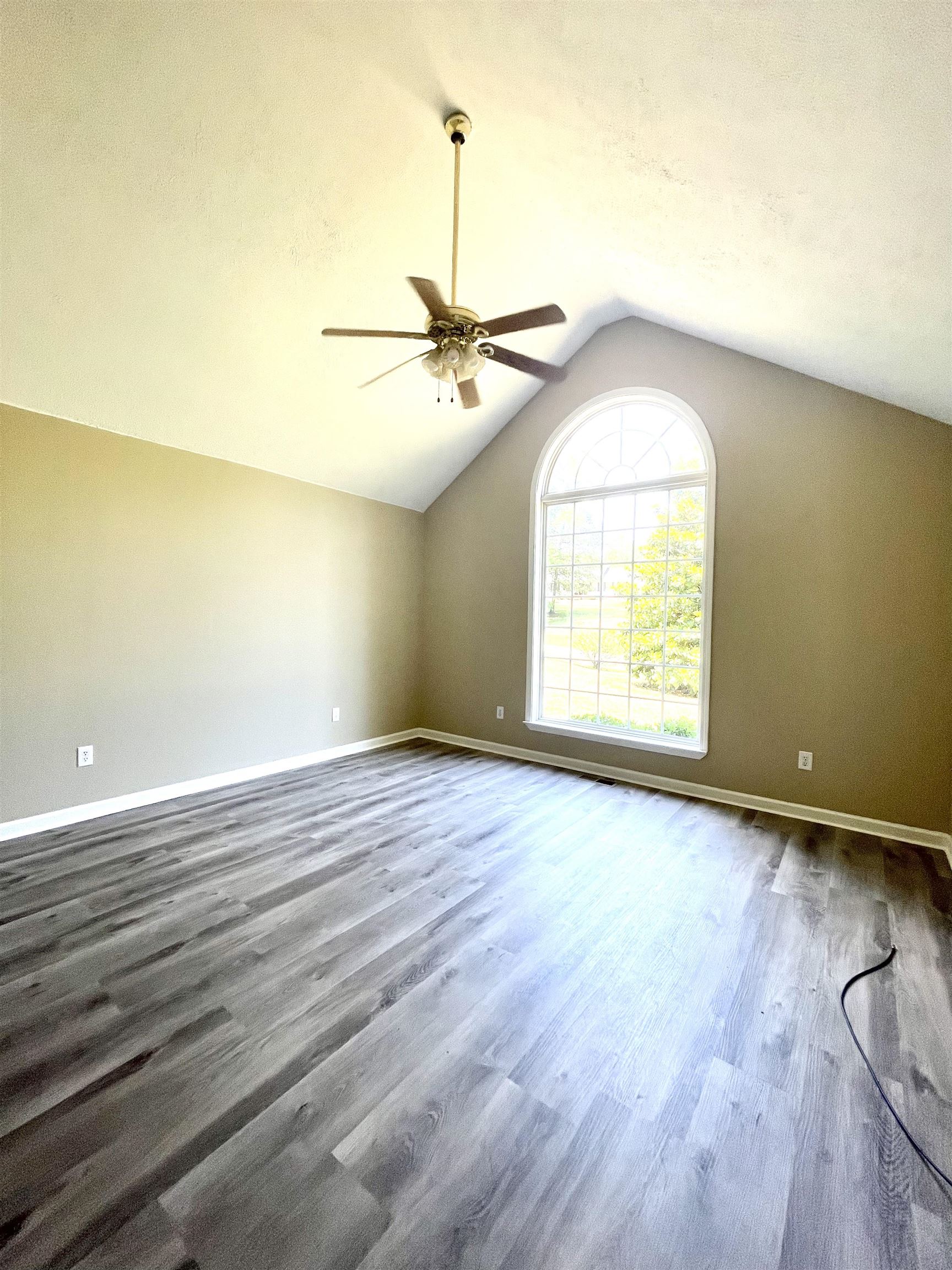 131 Wayne Elam Road Ramer, TN 38367 - Photo 8 of 15 an empty room with wooden floor and windows