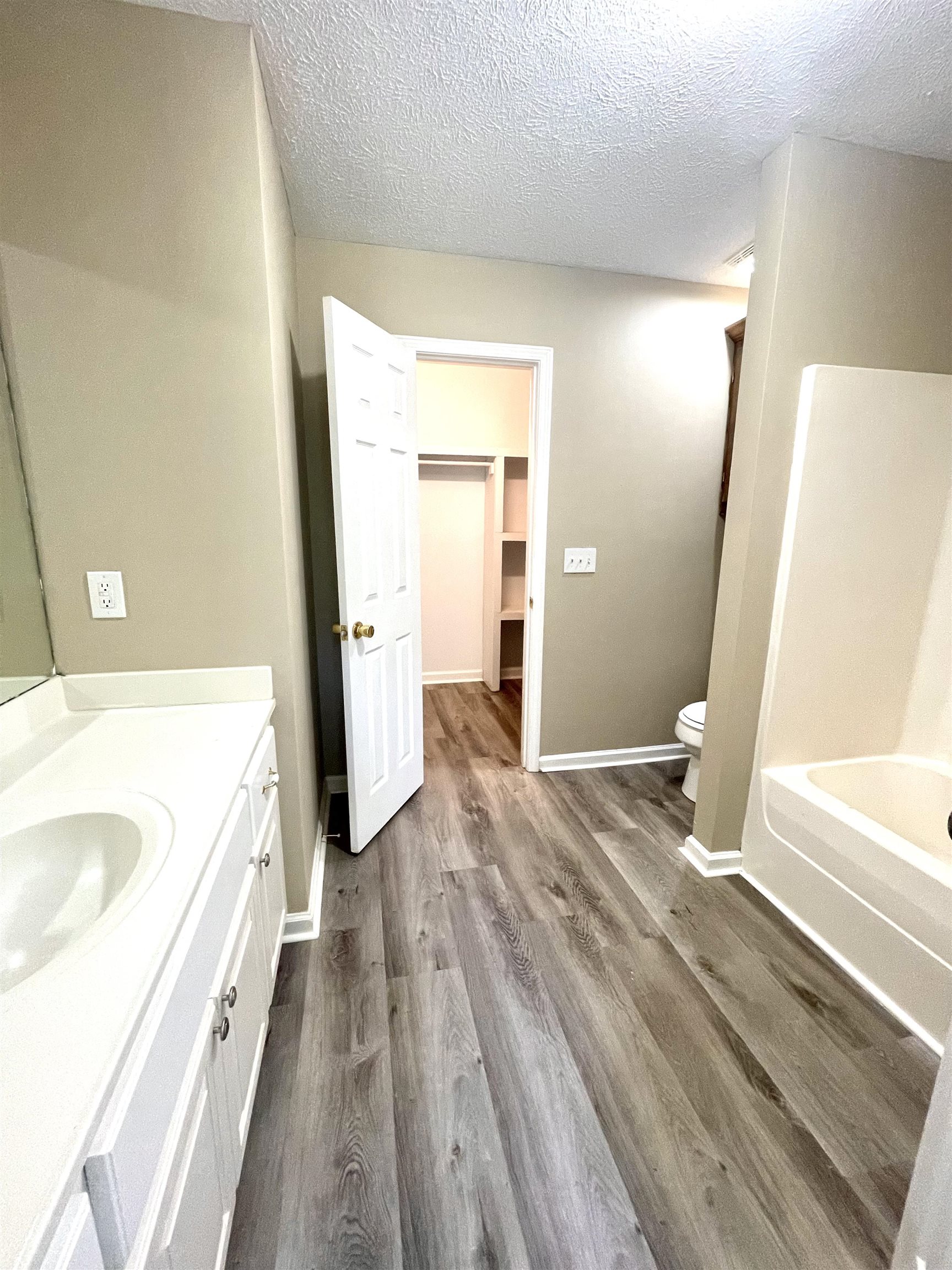 131 Wayne Elam Road Ramer, TN 38367 - Photo 9 of 15 a bathroom with a bathtub sink and a wooden floor