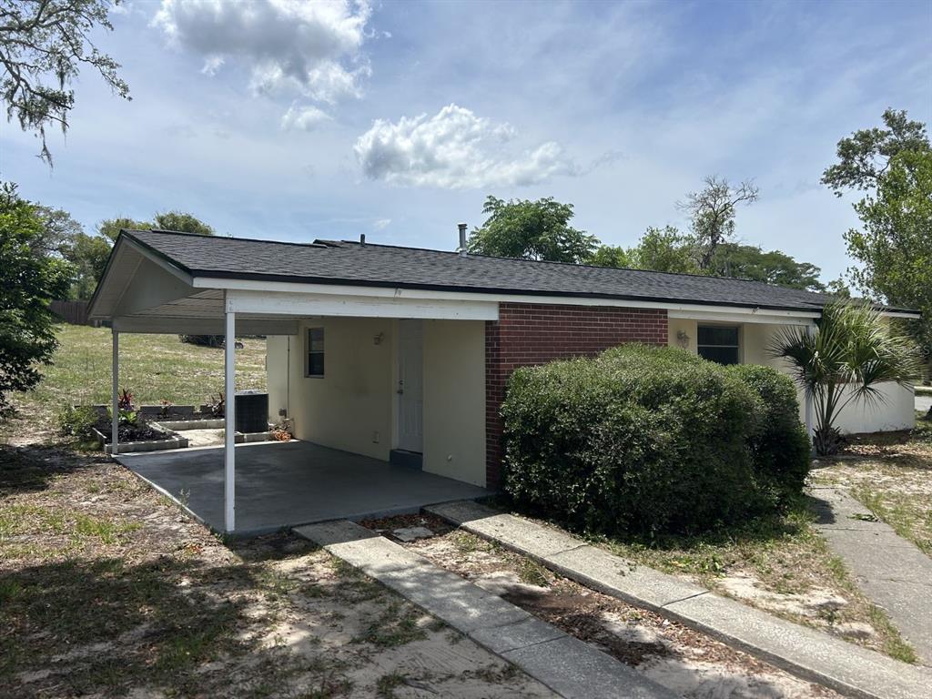 1241 Pilgrim Road Spring Hill, FL 34606 - Photo 28 of 28 a view of a house with a small yard and potted plants