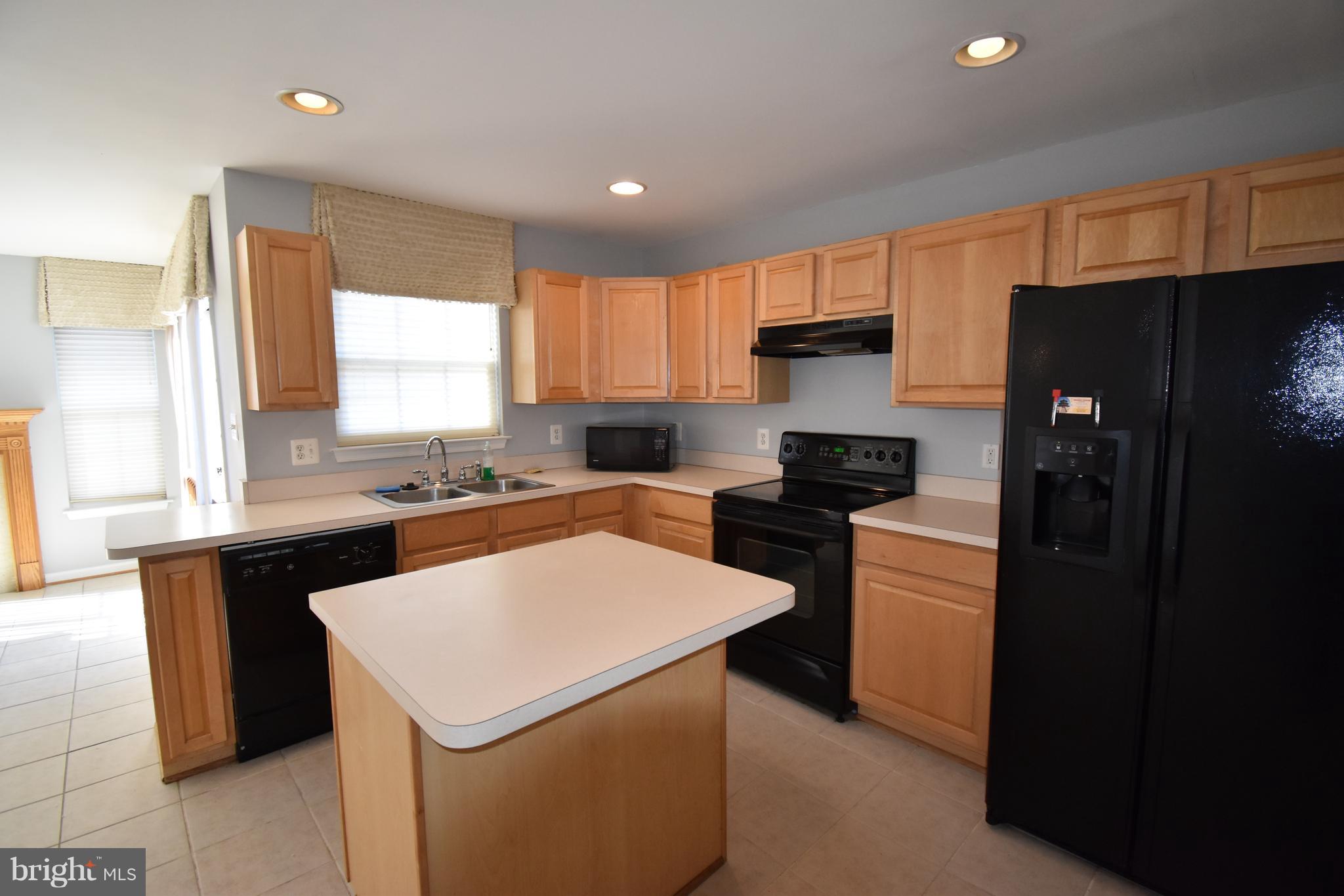 207 Canvasback Way Cambridge, MD 21613 - Photo 10 of 30 a kitchen with a refrigerator a stove a sink a counter top space and a window