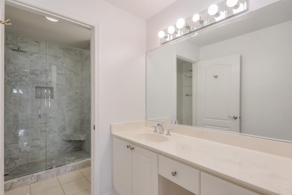 3475 Oak Valley Road Northeast, Unit 530 Atlanta, GA 30326 - Photo 22 of 37 a bathroom with a shower sink and a mirror